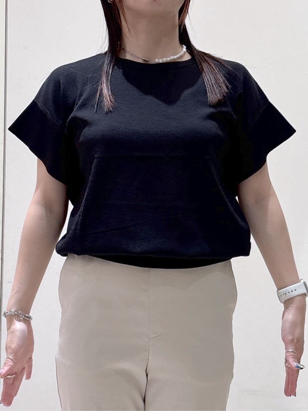 ブラック系のニット/セーター、ベージュ系のその他パンツ、ブラック系のトートバッグを着用したレディースの夏コーディネートの5枚目の写真