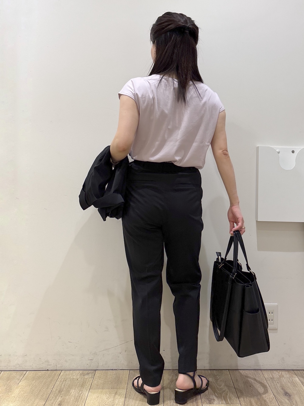 ピンク系のTシャツ/カットソー、ブラック系のその他パンツ、ブラック系のトートバッグを着用したレディースの春コーディネートの3枚目の写真