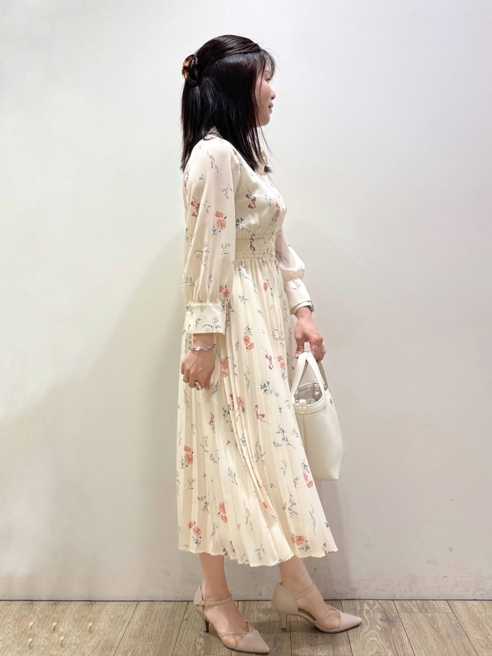 ベージュ系のパンプス、ホワイト系のショルダーバッグ、ブラウン系のトートバッグを着用したレディースの春コーディネートの2枚目の写真