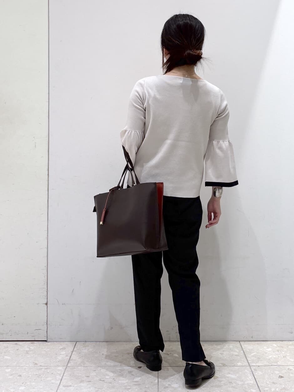グレー系のニット/セーター、ブラック系のその他パンツ、ブラウン系のトートバッグを着用したレディースの秋コーディネートの3枚目の写真