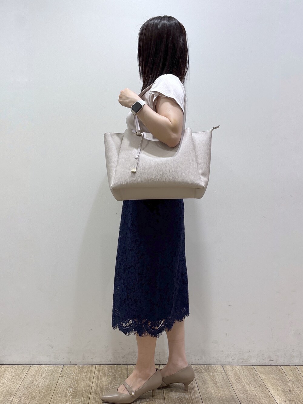 ベージュ系のTシャツ/カットソー、グレー系のトートバッグ、ベージュ系のパンプスを着用したレディースの夏コーディネートの2枚目の写真