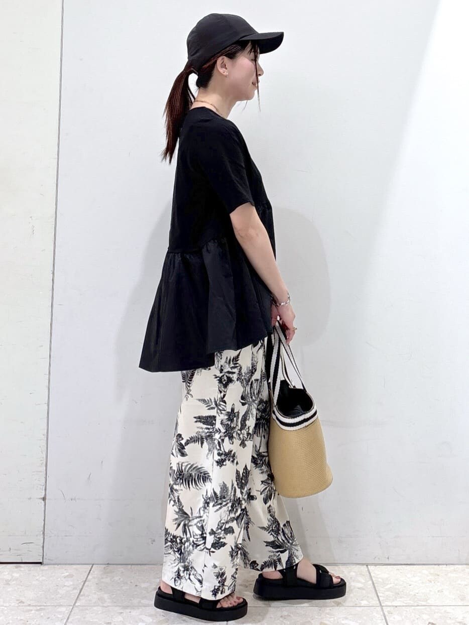 ブラック系のTシャツ/カットソー、ベージュ系のその他パンツ、ベージュ系のトートバッグを着用したレディースの春コーディネートの2枚目の写真