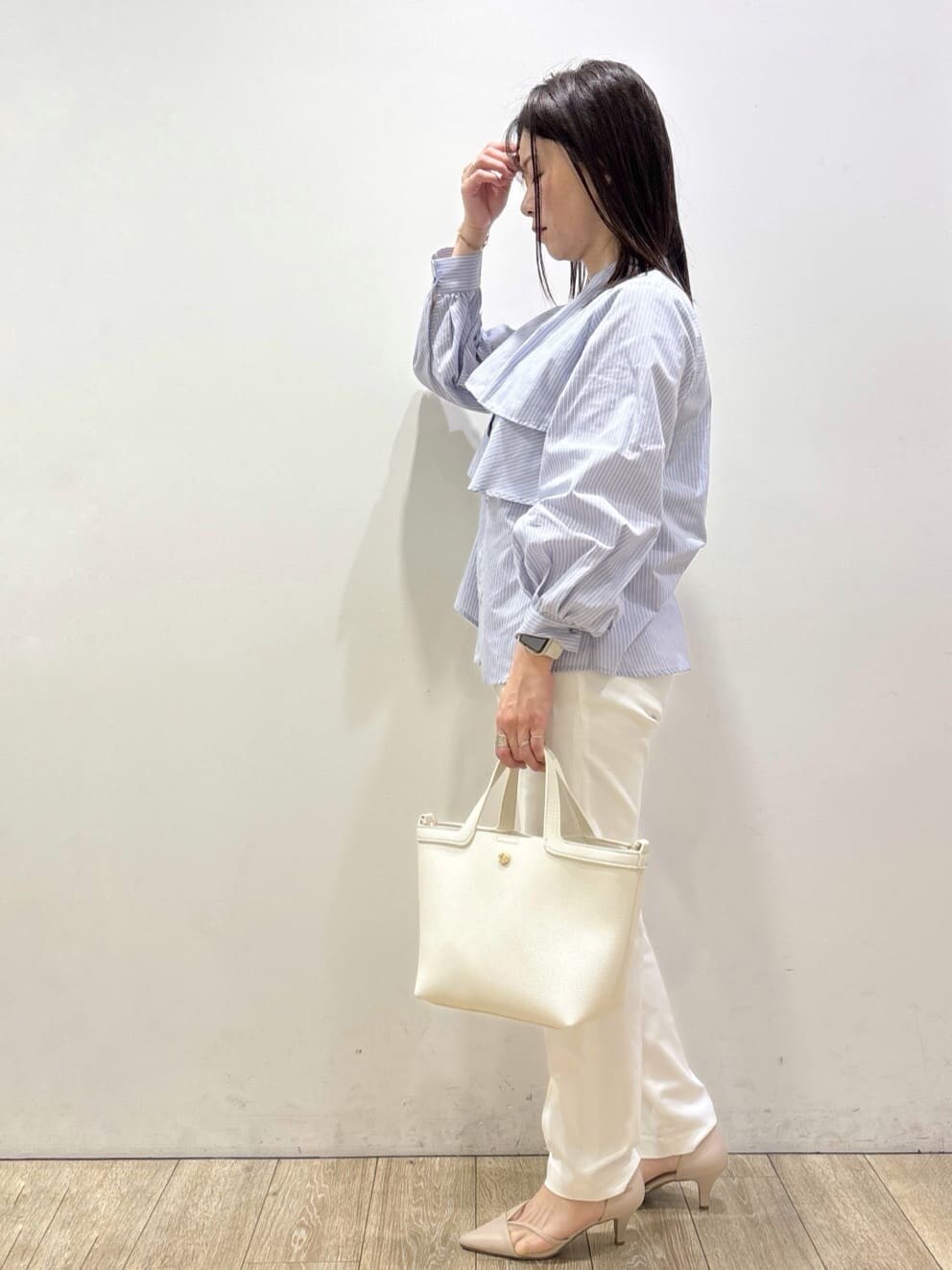 ベージュ系のパンプス、ブルー系のシャツ/ブラウス、ホワイト系のショルダーバッグを着用したレディースの春コーディネートの4枚目の写真
