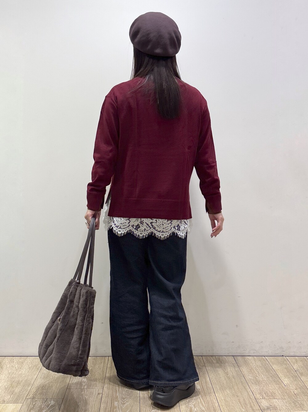 ブラウン系のノーカラーコート、レッド系のニット/セーター、ホワイト系のTシャツ/カットソーを着用したレディースの秋コーディネートの5枚目の写真