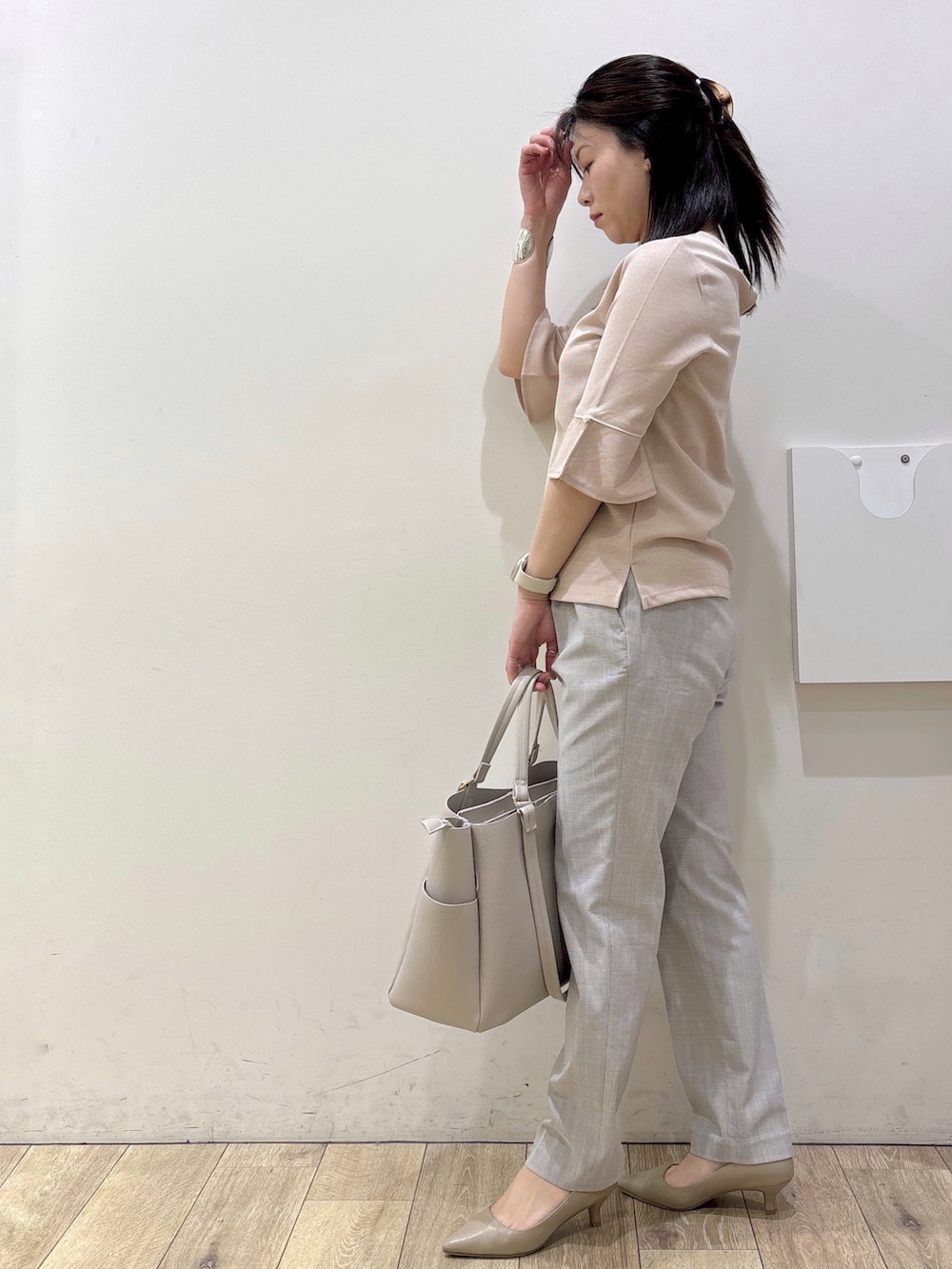 ベージュ系のパンプス、グレー系のカーディガン/ボレロ、ベージュ系のトートバッグを着用したレディースの春コーディネートの4枚目の写真