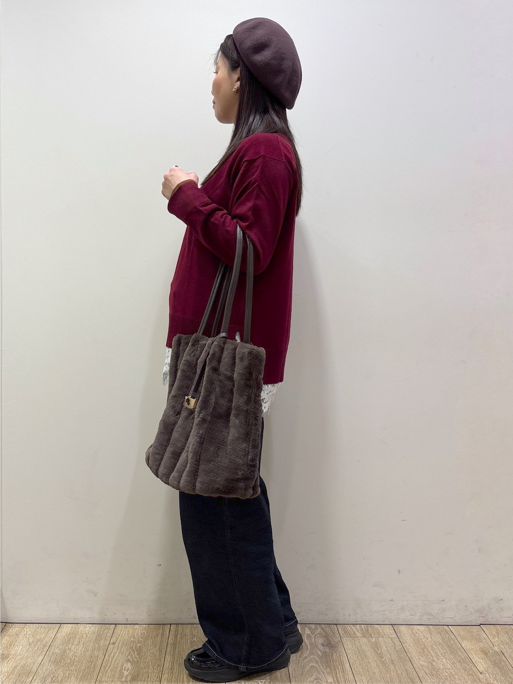 ブラウン系のノーカラーコート、レッド系のニット/セーター、ホワイト系のTシャツ/カットソーを着用したレディースの秋コーディネートの2枚目の写真