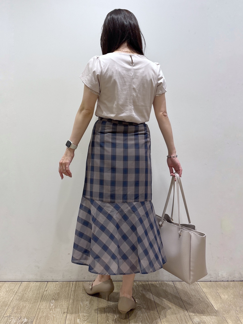 ベージュ系のTシャツ/カットソー、ブラウン系のスカート、グレー系のトートバッグを着用したレディースの夏コーディネートの4枚目の写真