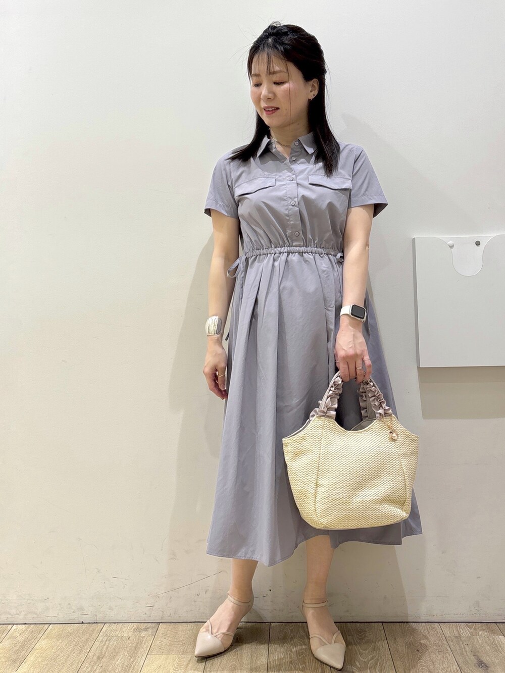 グレー系のワンピース、ベージュ系のトートバッグ、ベージュ系のパンプスを着用したレディースの春コーディネートの6枚目の写真