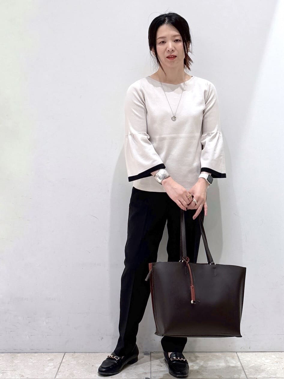 グレー系のニット/セーター、ブラック系のその他パンツ、ブラウン系のトートバッグを着用したレディースの秋コーディネートの5枚目の写真