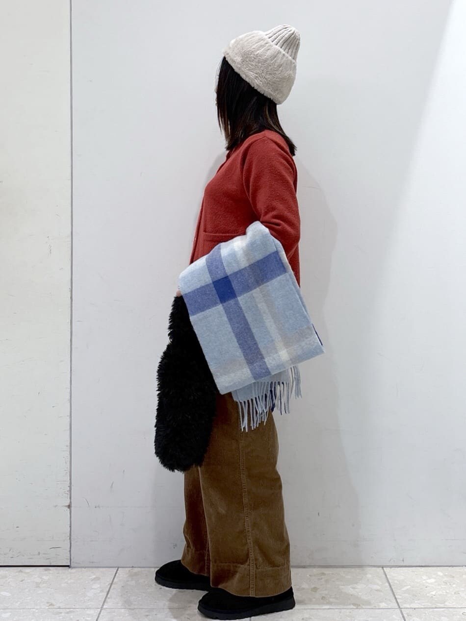 レッド系のカーディガン/ボレロ、イエロー系のその他パンツ、ブラック系のハンドバッグを着用したレディースの冬コーディネートの4枚目の写真