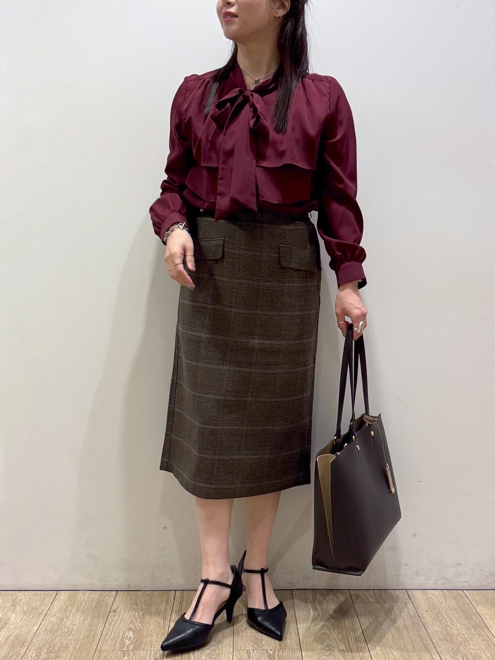 ベージュ系のカーディガン/ボレロ、レッド系のシャツ/ブラウス、ブラウン系のスカートを着用したレディースの秋コーディネートの8枚目の写真