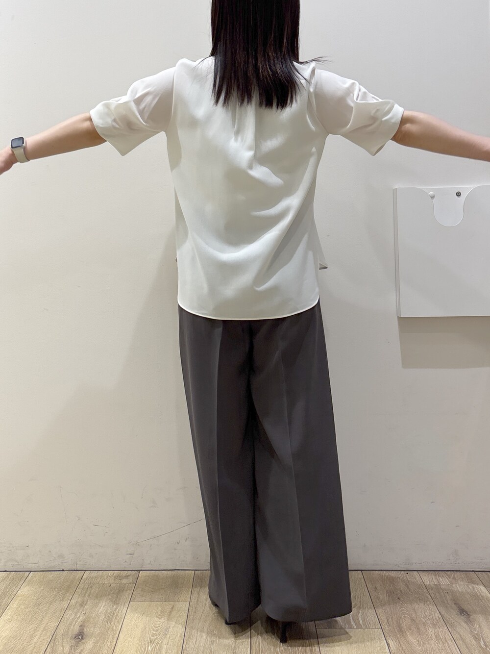 ブラック系のトートバッグ、ブラック系のパンプス、ホワイト系のシャツ/ブラウスを着用したレディースの春コーディネートの7枚目の写真