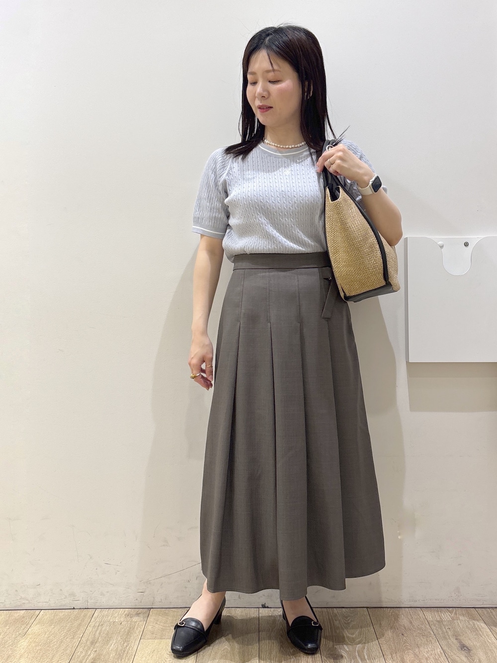 ブラック系のパンプス、ホワイト系のシャツ/ブラウス、ブルー系のニット/セーターを着用したレディースの春コーディネートの2枚目の写真