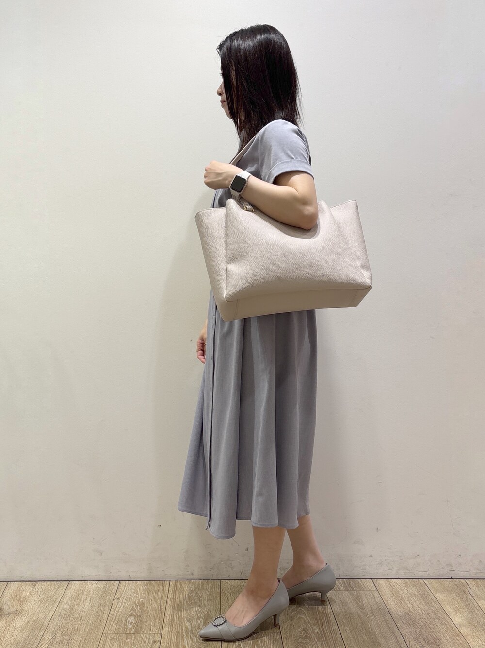 グレー系のワンピース、グレー系のトートバッグ、グレー系のパンプスを着用したレディースの夏コーディネートの5枚目の写真
