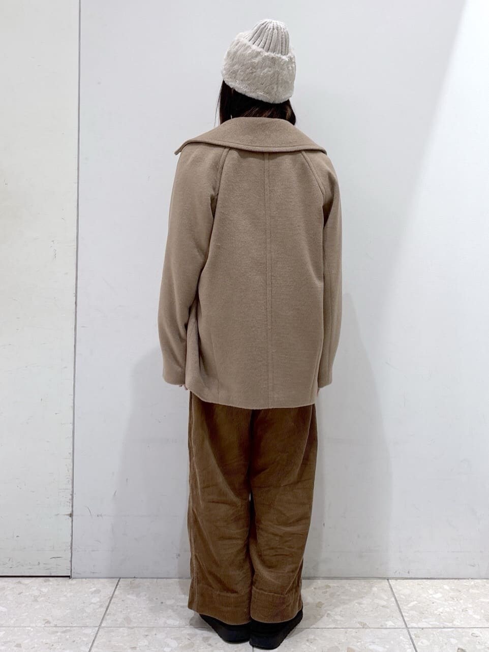 ベージュ系のピーコート、レッド系のカーディガン/ボレロ、イエロー系のその他パンツを着用したレディースの冬コーディネートの3枚目の写真