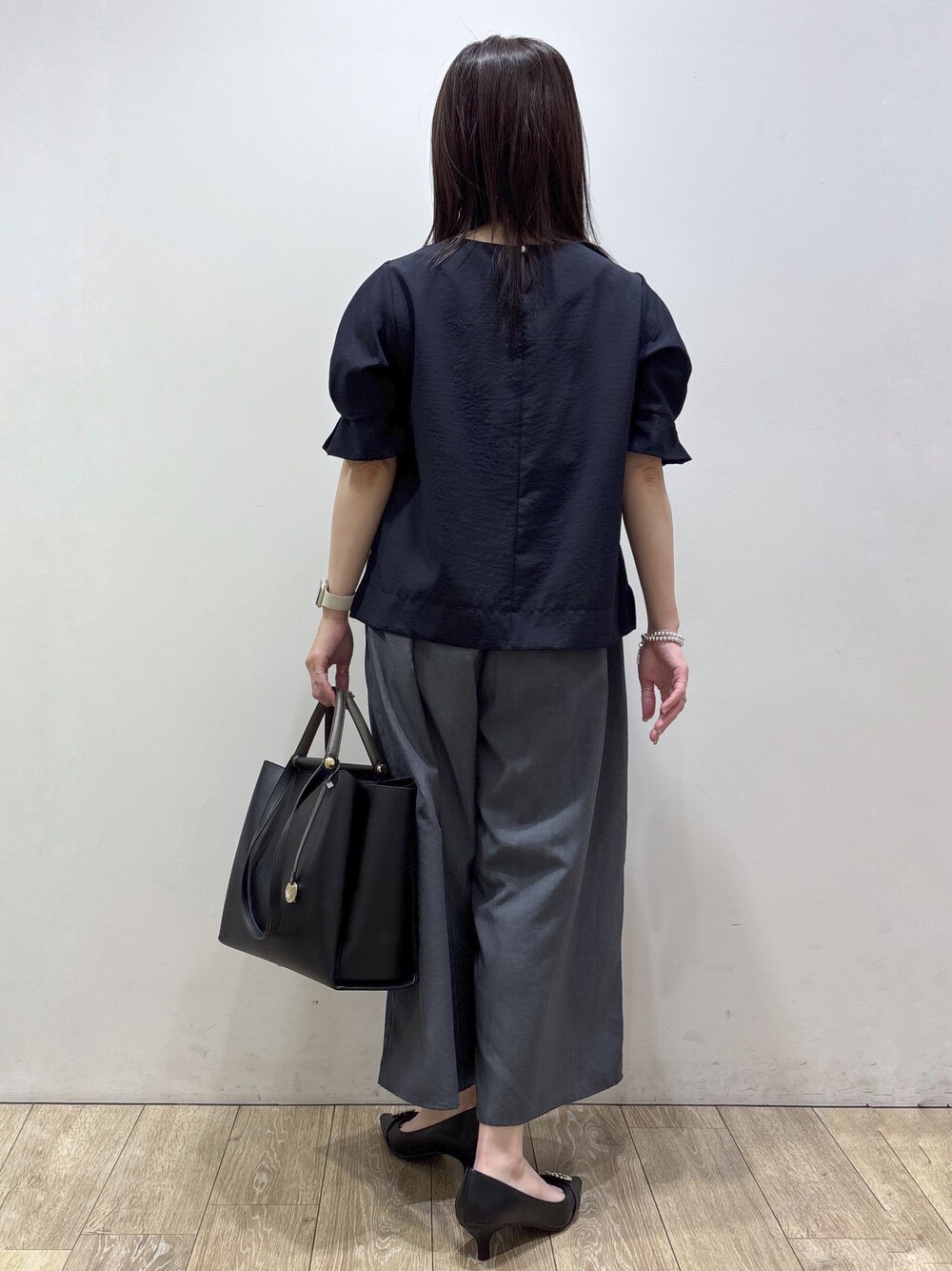 ブルー系のシャツ/ブラウス、グレー系のその他パンツ、ブラック系のトートバッグを着用したレディースの夏コーディネートの5枚目の写真