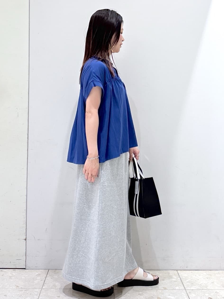 ブルー系のTシャツ/カットソー、グレー系のスカート、ブラック系のトートバッグを着用したレディースの夏コーディネートの2枚目の写真