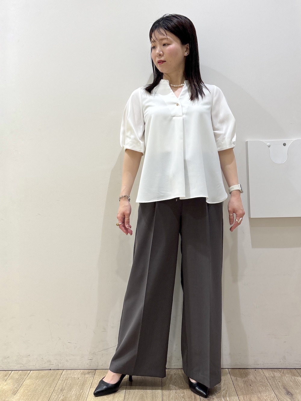ブラック系のトートバッグ、ブラック系のパンプス、ホワイト系のシャツ/ブラウスを着用したレディースの春コーディネートの5枚目の写真