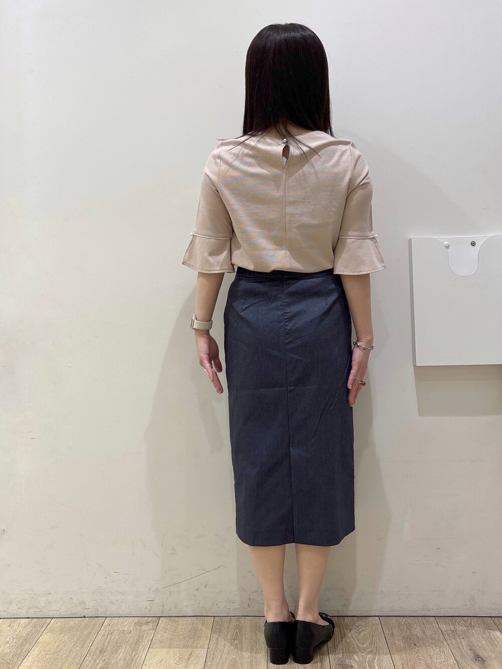 ブラック系のパンプス、ブラック系のトートバッグ、ブルー系のスカートを着用したレディースの春コーディネートの7枚目の写真