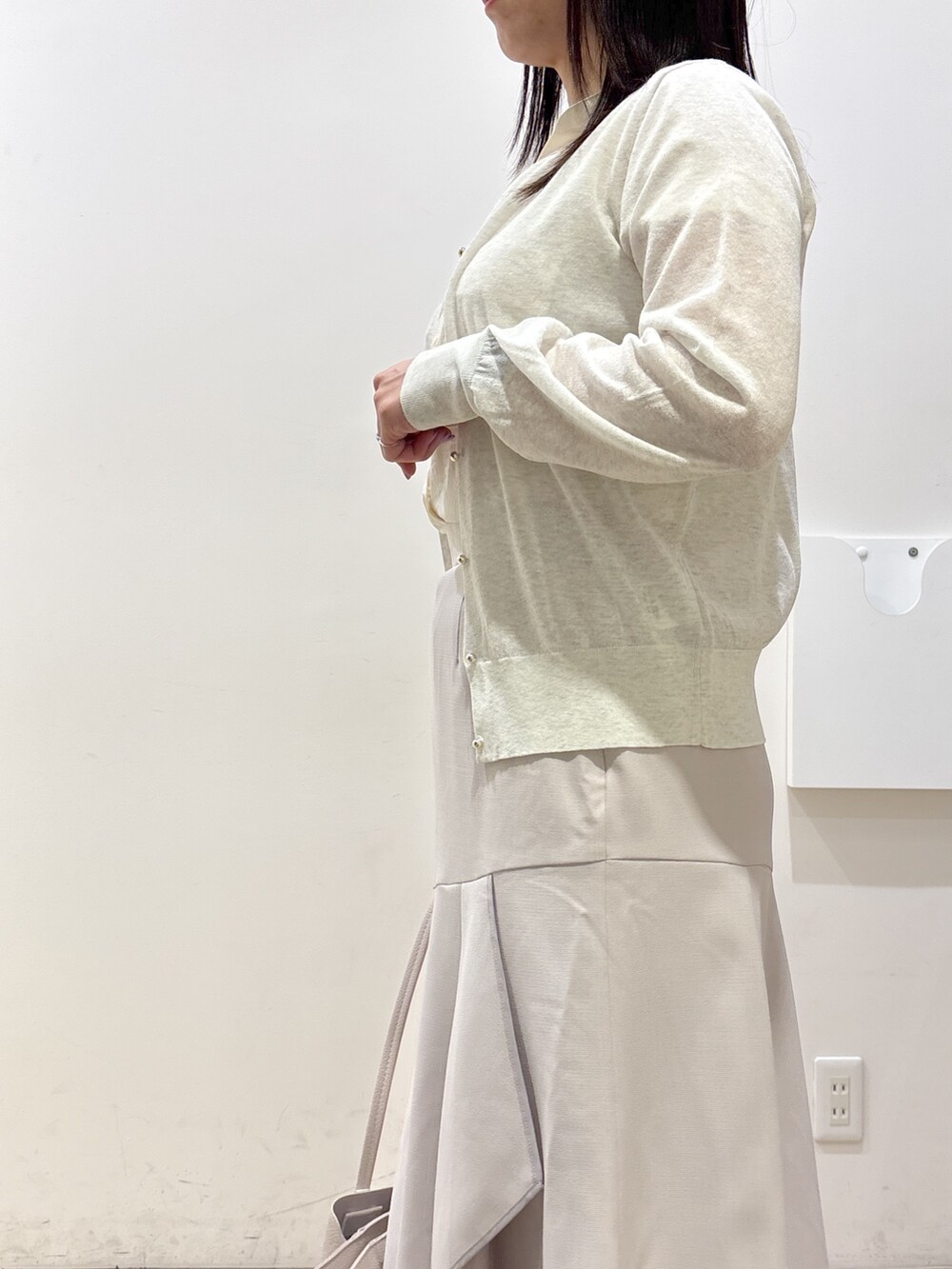 ホワイト系のカーディガン/ボレロ、ホワイト系のシャツ/ブラウス、ベージュ系のスカートを着用したレディースの夏コーディネートの9枚目の写真