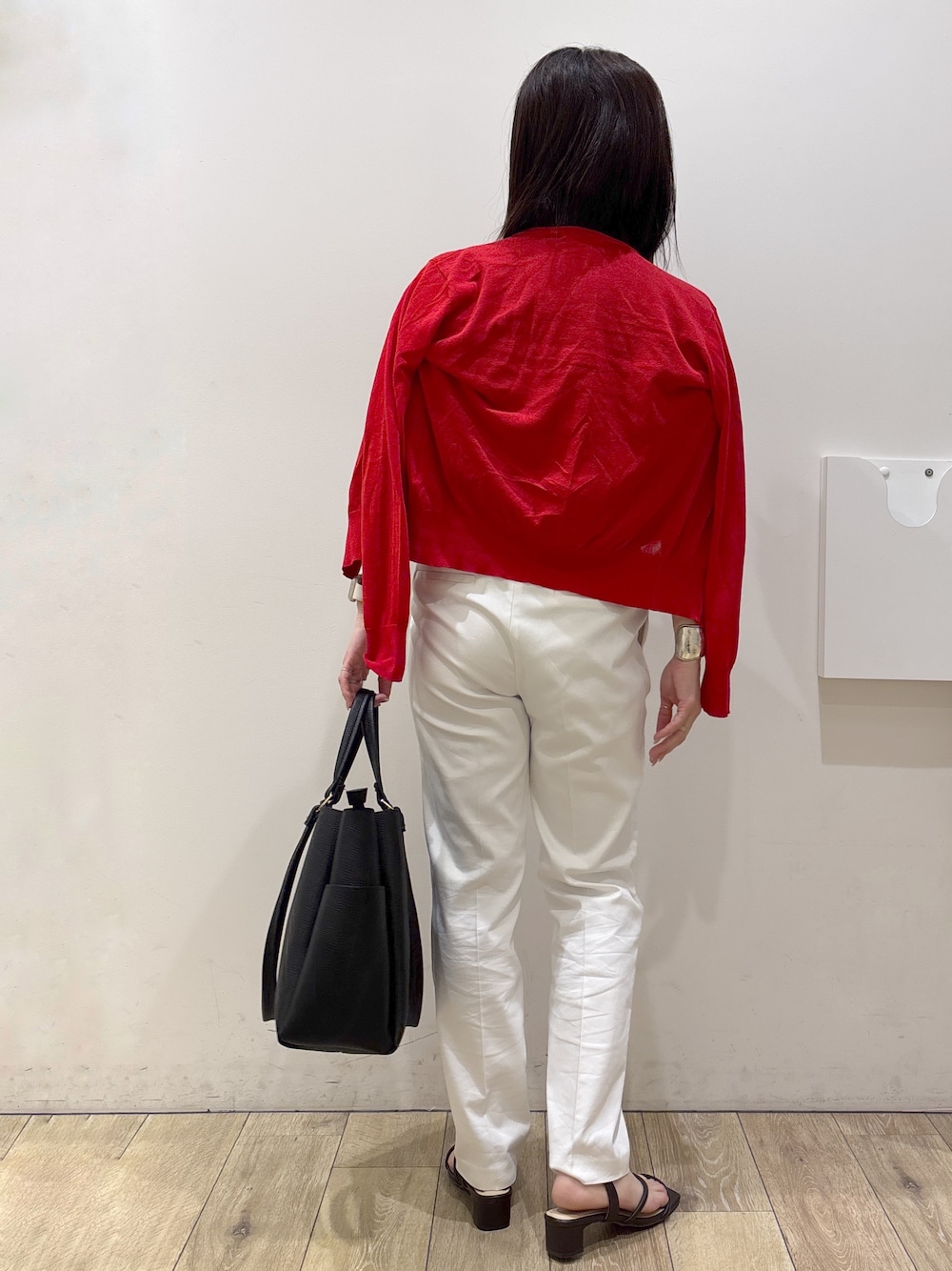ブラック系のトートバッグ、ブラウン系のサンダル、ホワイト系のその他パンツを着用したレディースの春コーディネートの3枚目の写真