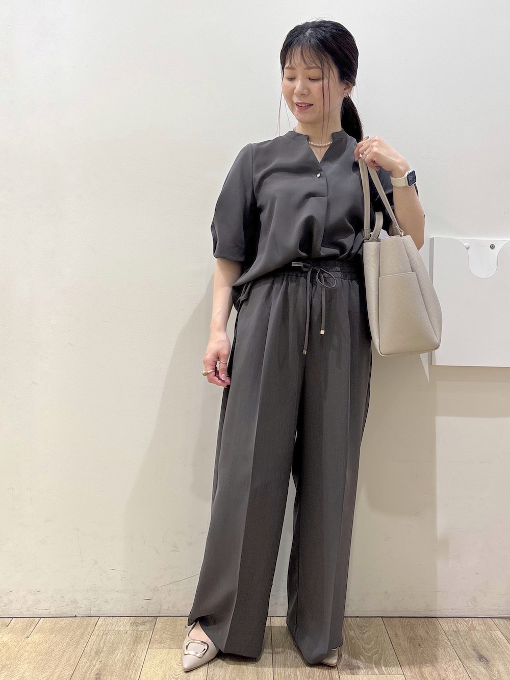 ベージュ系のパンプス、グレー系のカーディガン/ボレロ、ベージュ系のトートバッグを着用したレディースの春コーディネートの5枚目の写真
