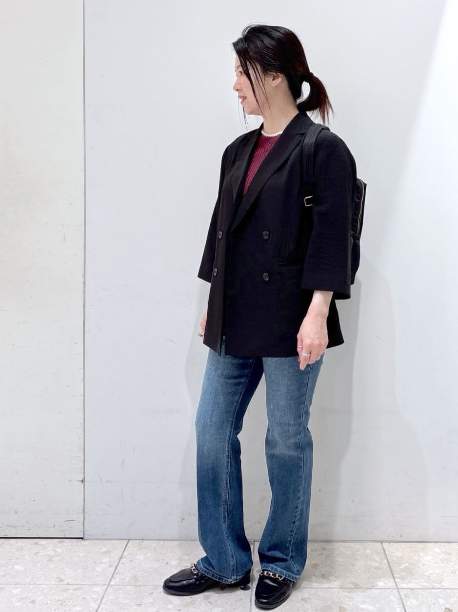 レッド系のニット/セーター、ブルー系のデニムパンツ、ブラック系のバックパック/リュックを着用したレディースの秋コーディネートの8枚目の写真