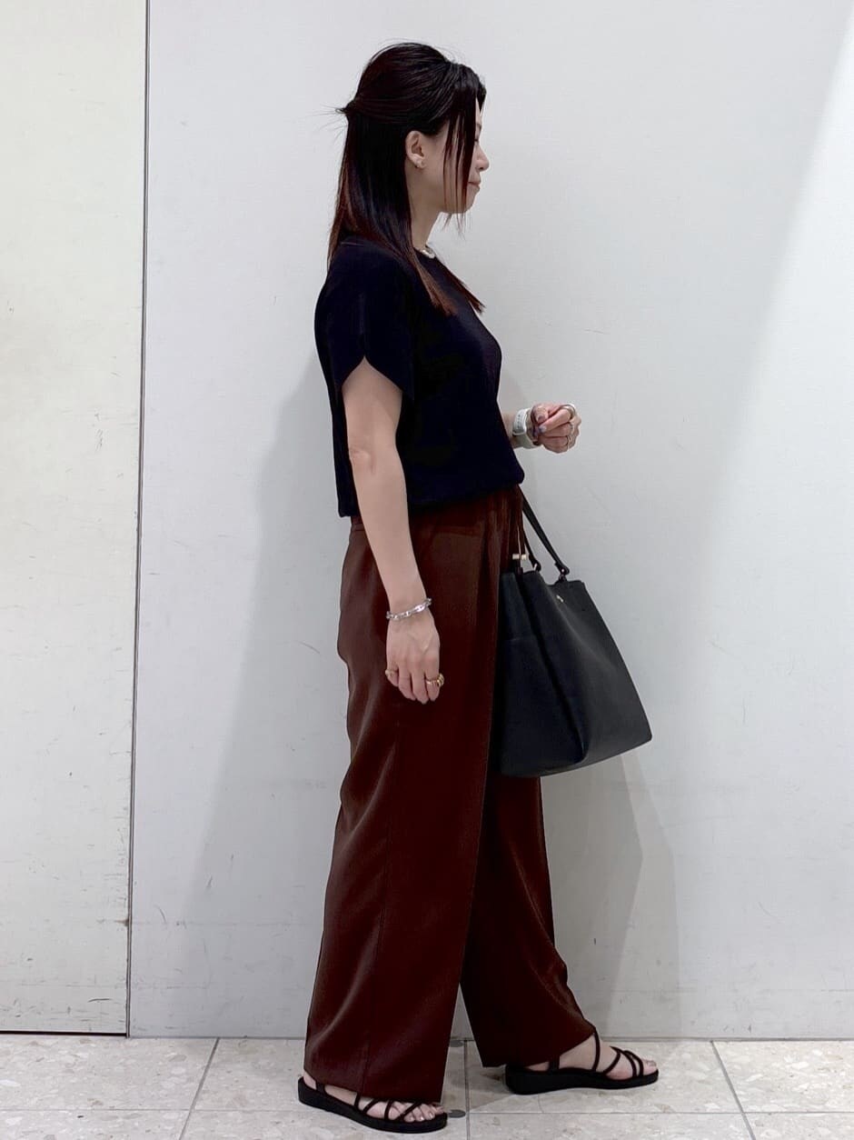 ブラック系のニット/セーター、ブラウン系のその他パンツ、ブラック系のトートバッグを着用したレディースの夏コーディネートの2枚目の写真