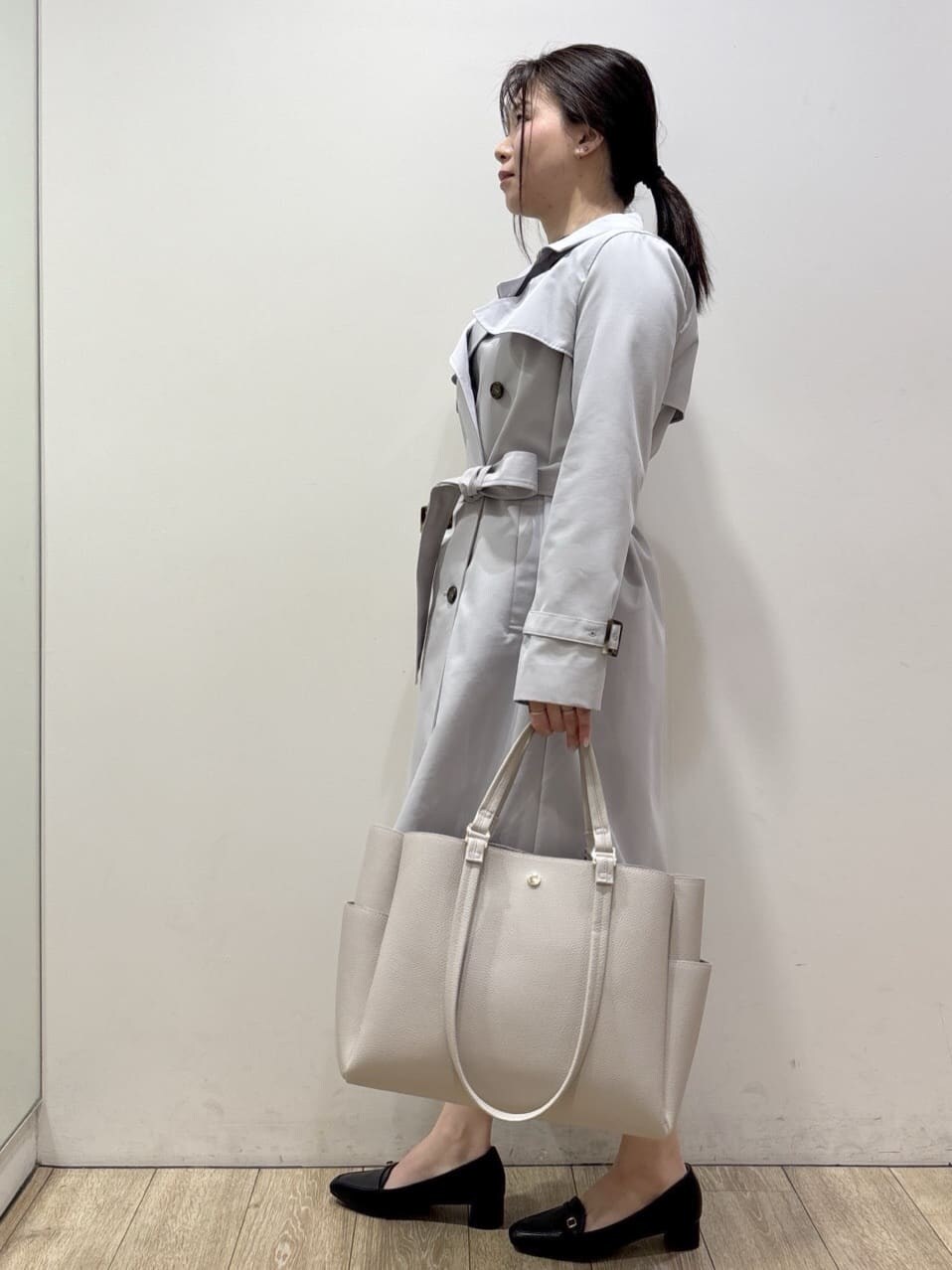 ブルー系のトレンチコート、ブラック系のパンプス、グレー系のカーディガン/ボレロを着用したレディースの冬コーディネートの2枚目の写真