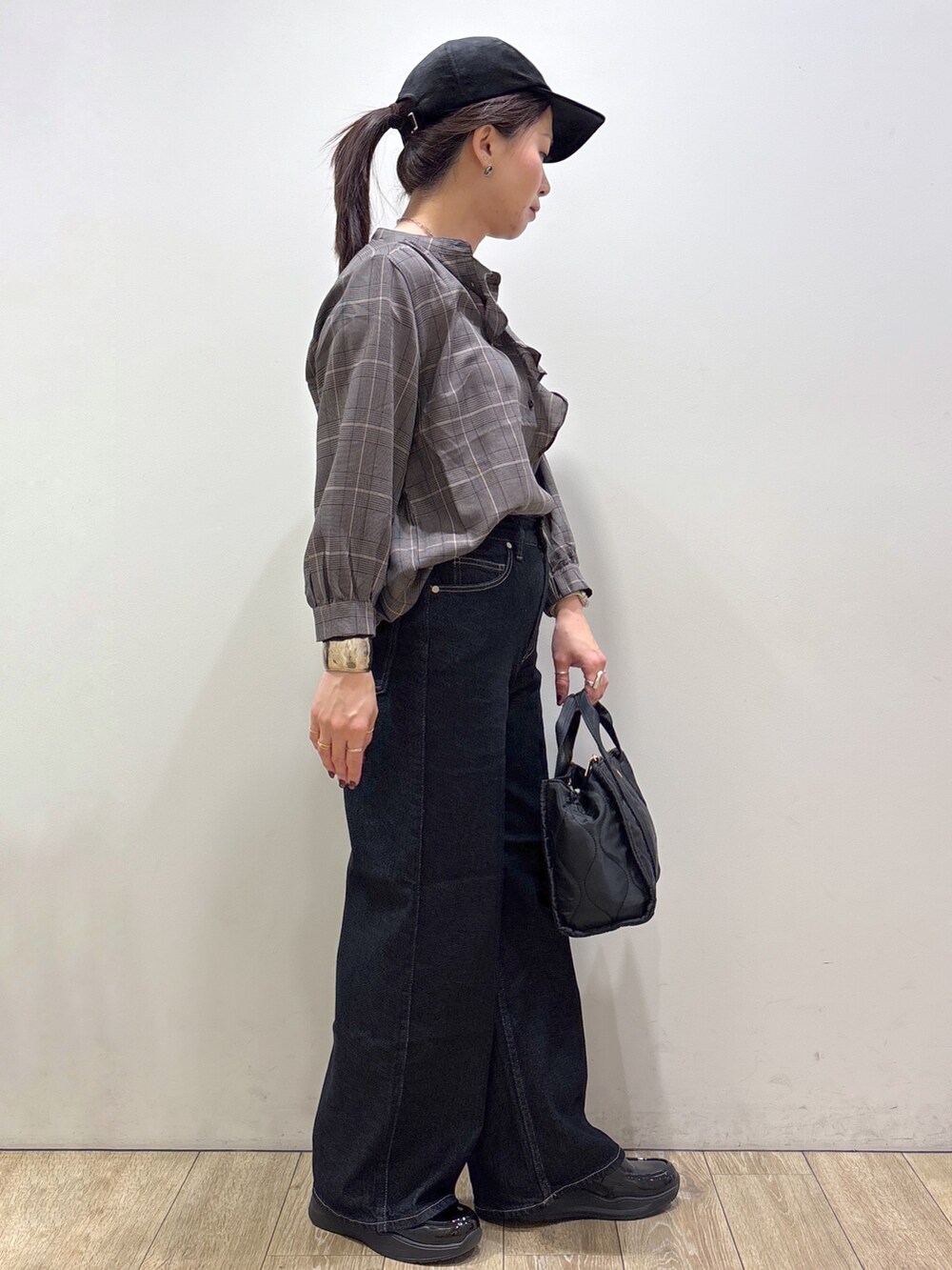 グレー系のシャツ/ブラウス、ブルー系のデニムパンツ、ブラック系のトートバッグを着用したレディースの秋コーディネートの2枚目の写真