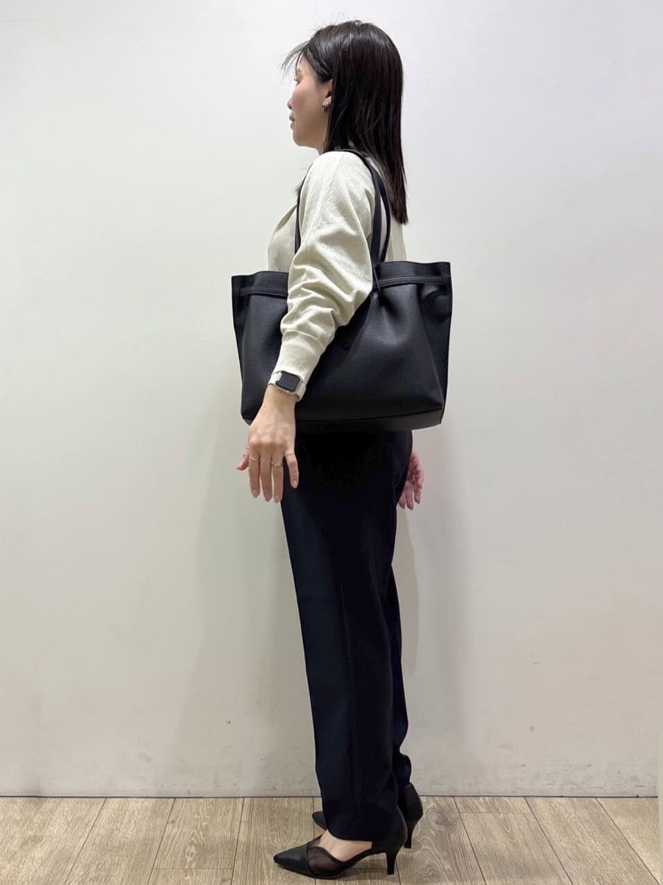 ホワイト系のニット/セーター、ブルー系のその他パンツ、ブラック系のトートバッグを着用したレディースの春コーディネートの2枚目の写真