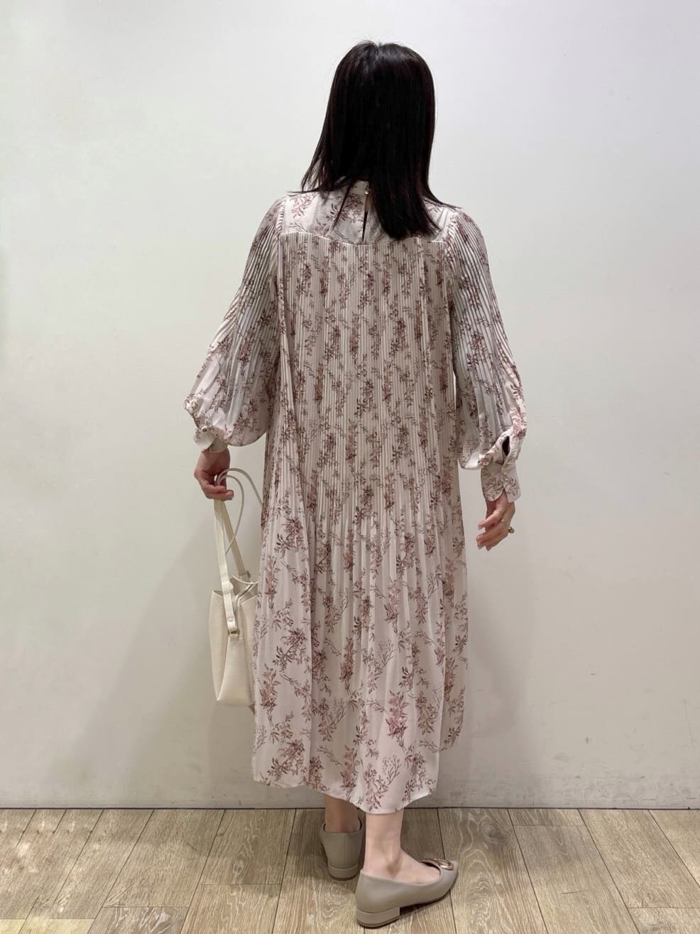 ホワイト系のショルダーバッグ、ベージュ系のパンプス、レッド系のスカートを着用したレディースの冬コーディネートの8枚目の写真