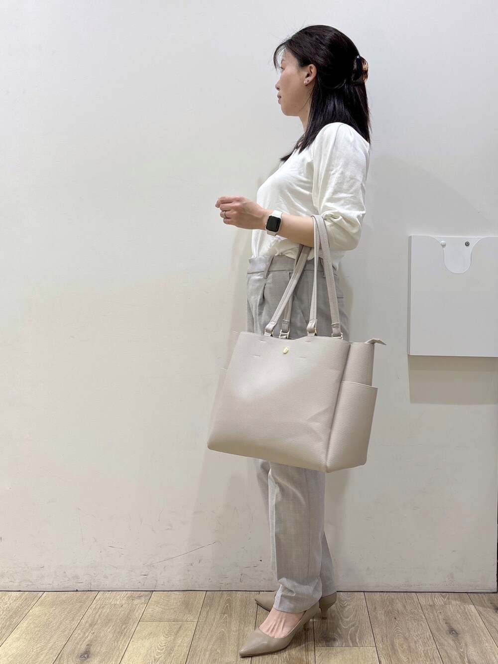 ベージュ系のパンプス、グレー系のカーディガン/ボレロ、ベージュ系のトートバッグを着用したレディースの春コーディネートの2枚目の写真