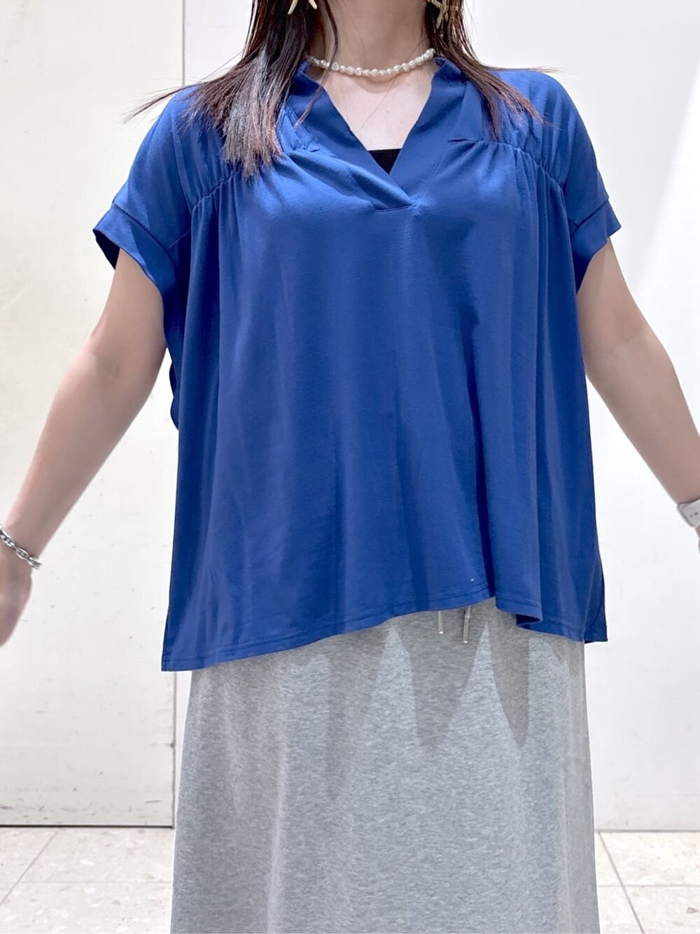 ブルー系のTシャツ/カットソー、グレー系のスカート、ブラック系のトートバッグを着用したレディースの夏コーディネートの5枚目の写真