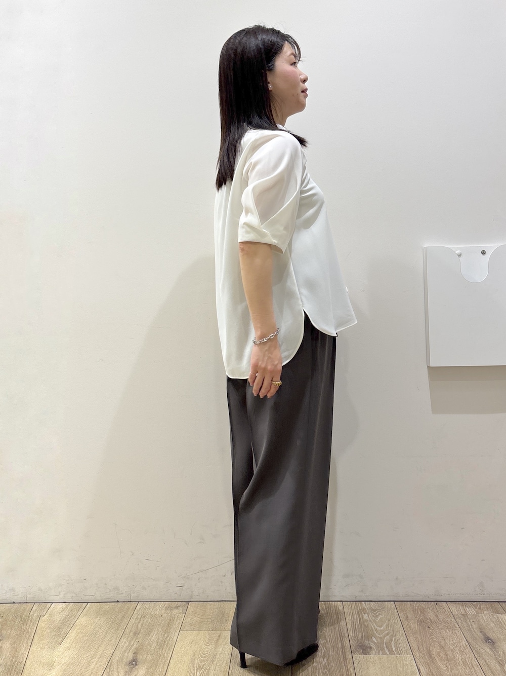 ブラック系のトートバッグ、ブラック系のパンプス、ホワイト系のシャツ/ブラウスを着用したレディースの春コーディネートの6枚目の写真