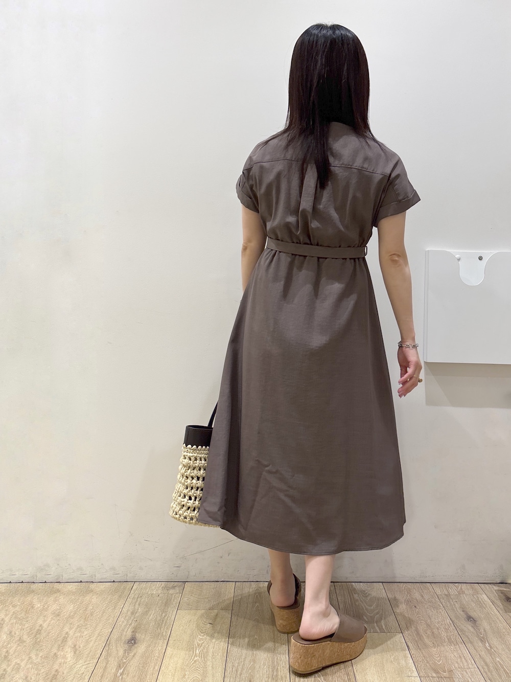 ブラウン系のワンピース、ブラウン系のトートバッグ、ベージュ系のサンダルを着用したレディースの夏コーディネートの3枚目の写真