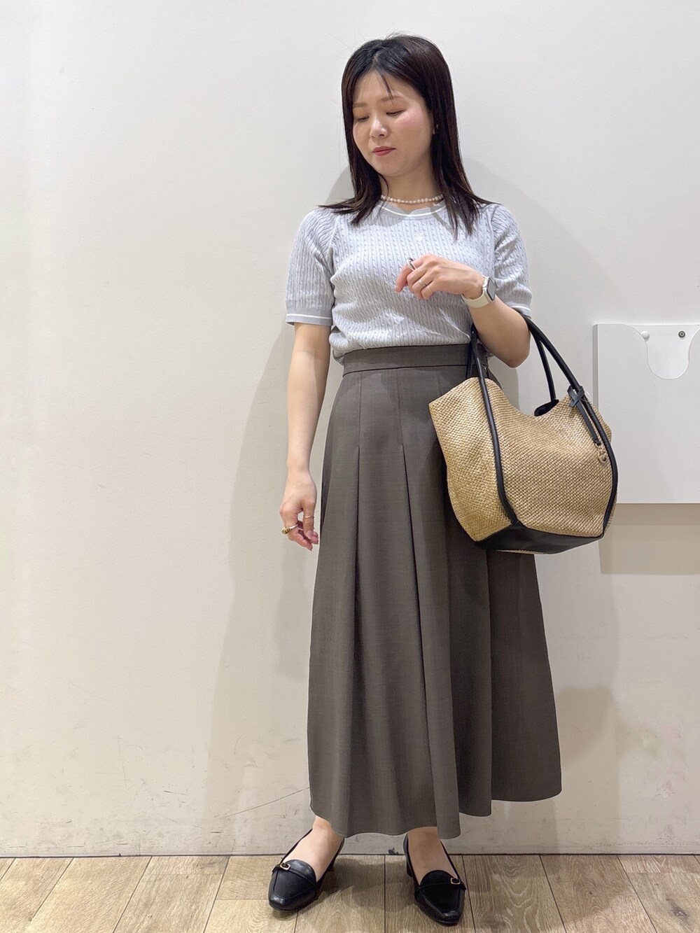 ブラック系のパンプス、ホワイト系のカーディガン/ボレロ、ホワイト系のシャツ/ブラウスを着用したレディースの春コーディネートの5枚目の写真