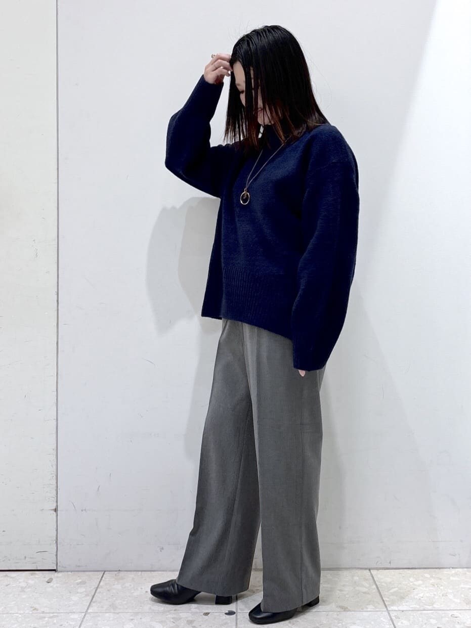 ブルー系のニット/セーター、グレー系のその他パンツ、ブラック系のショルダーバッグを着用したレディースの冬コーディネートの6枚目の写真