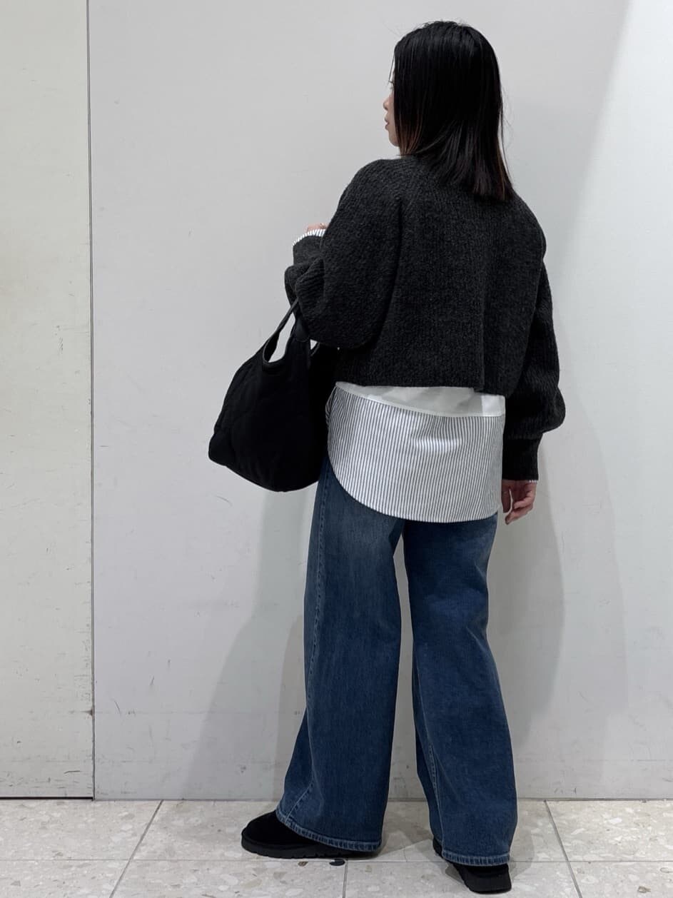 グレー系のニット/セーター、ホワイト系のTシャツ/カットソー、ブルー系のデニムパンツを着用したレディースの冬コーディネートの4枚目の写真