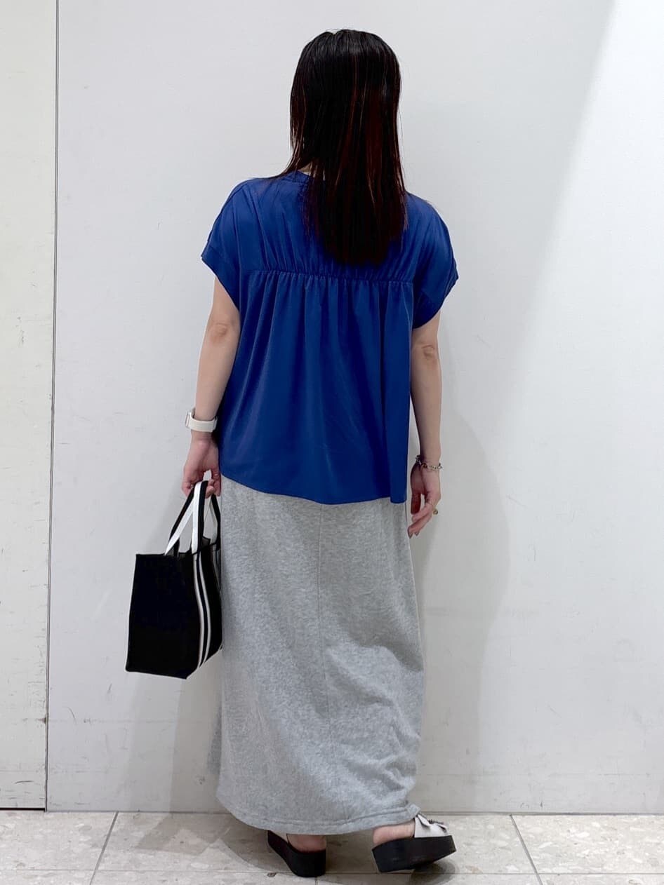 ブルー系のTシャツ/カットソー、グレー系のスカート、ブラック系のトートバッグを着用したレディースの夏コーディネートの3枚目の写真