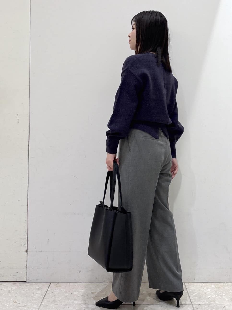 ブルー系のニット/セーター、グレー系のその他パンツ、ブラック系のトートバッグを着用したレディースの冬コーディネートの4枚目の写真