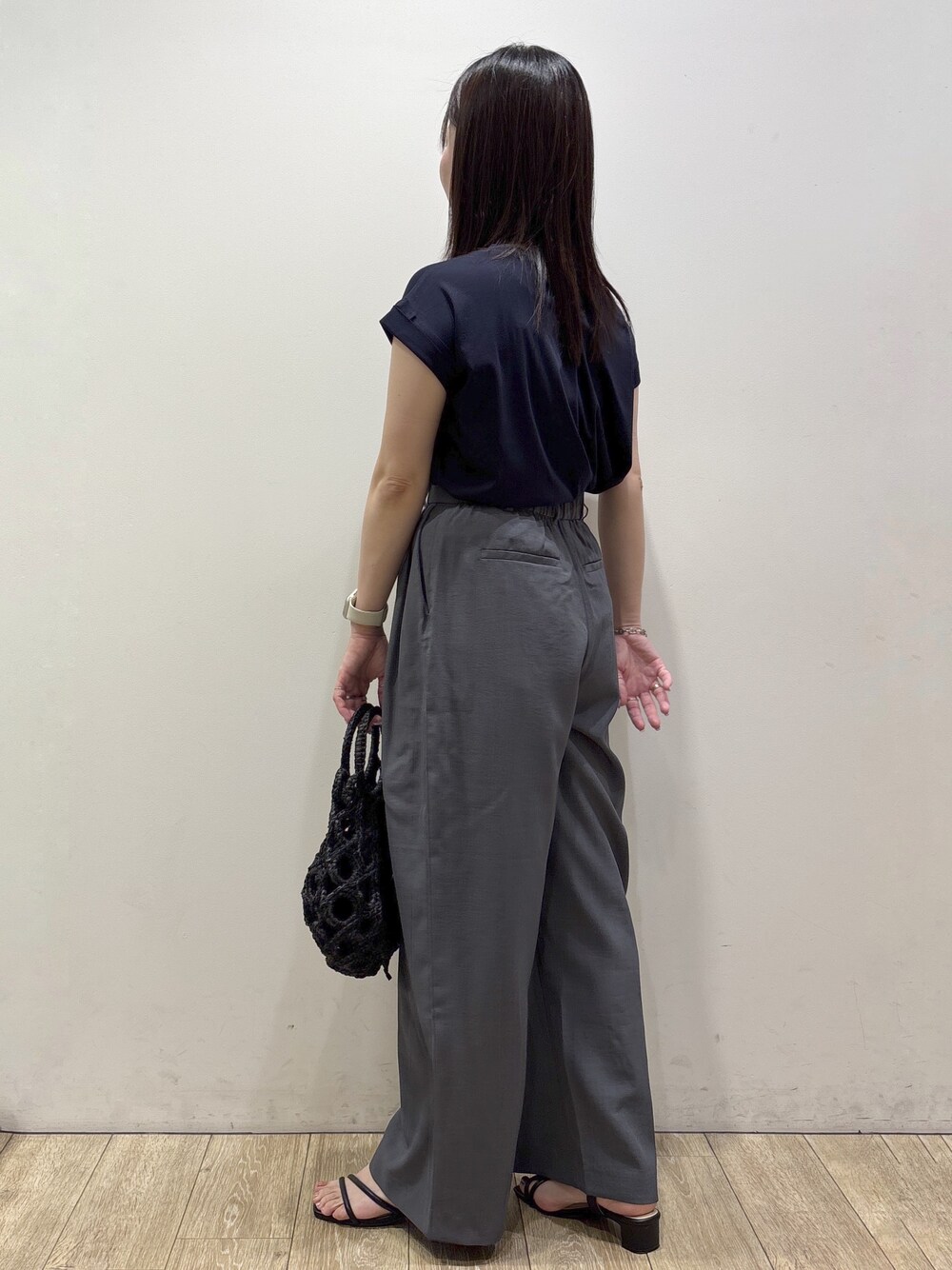 ブルー系のTシャツ/カットソー、グレー系のその他パンツ、ブラック系のハンドバッグを着用したレディースの夏コーディネートの5枚目の写真