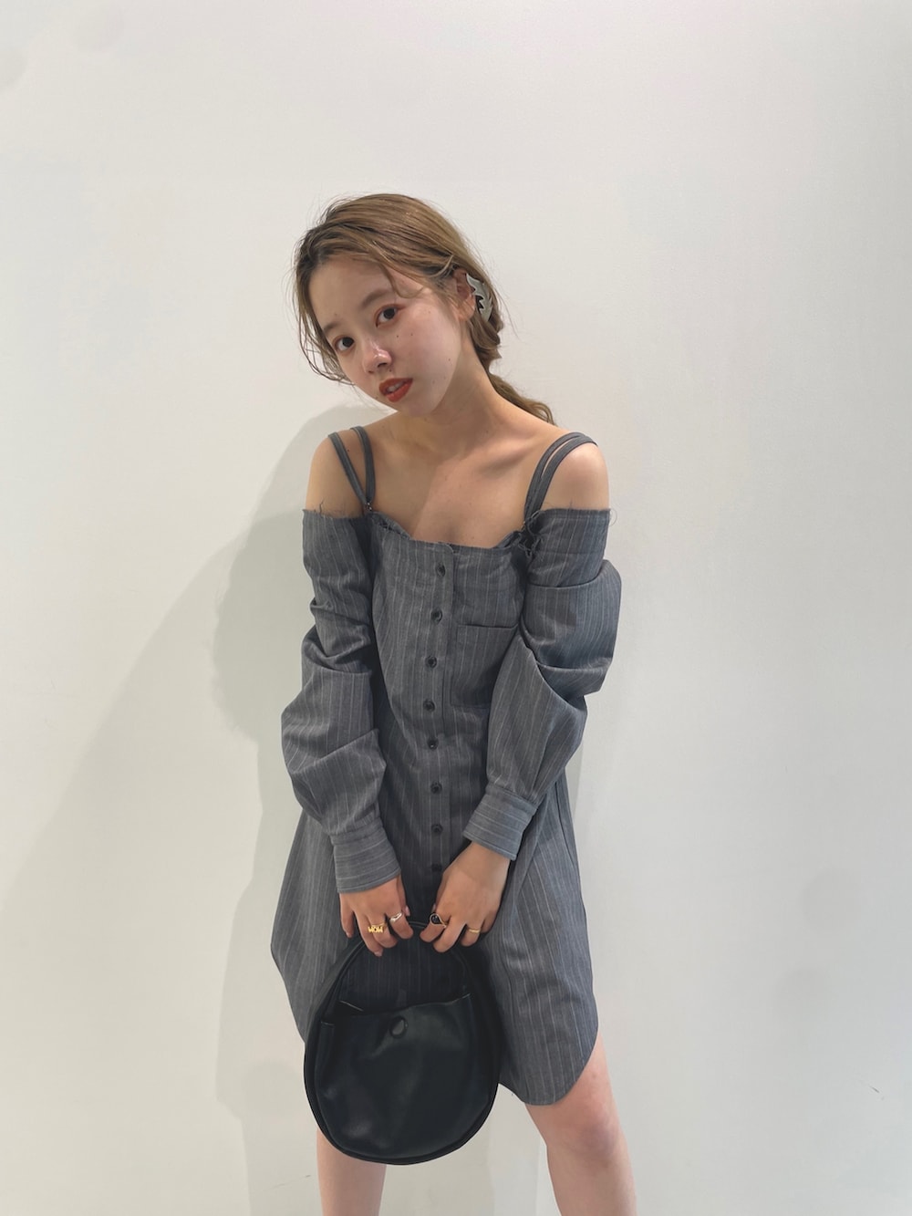 ブラック系のハンドバッグ、グレー系のワンピースを着用したレディースの夏コーディネートの3枚目の写真