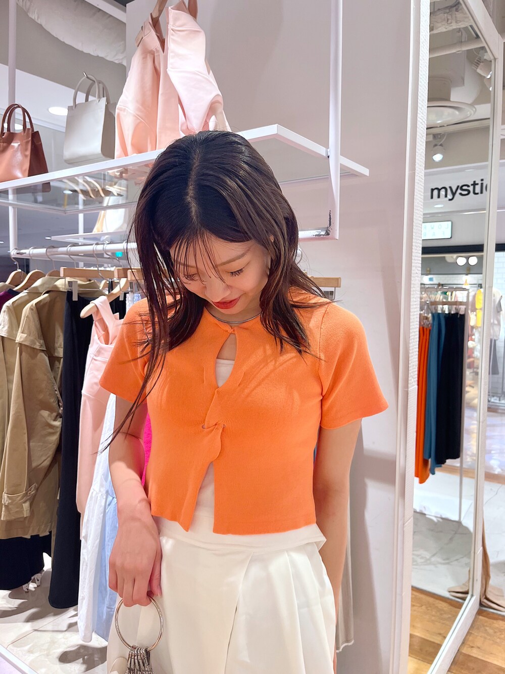 オレンジ系のニット/セーター、ホワイト系のその他パンツ、ホワイト系のサンダルを着用したレディースの春コーディネートの2枚目の写真