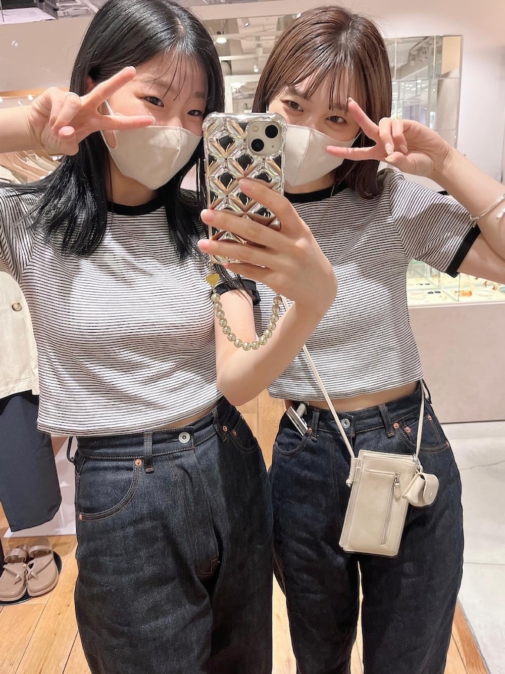 ブルー系のデニムパンツ、ブラック系のサンダル、ホワイト系のTシャツ/カットソーを着用したレディースの夏コーディネートの2枚目の写真