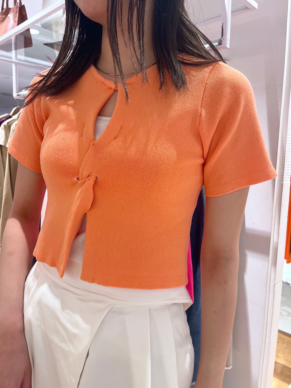 オレンジ系のニット/セーター、ホワイト系のその他パンツ、ホワイト系のサンダルを着用したレディースの春コーディネートの3枚目の写真