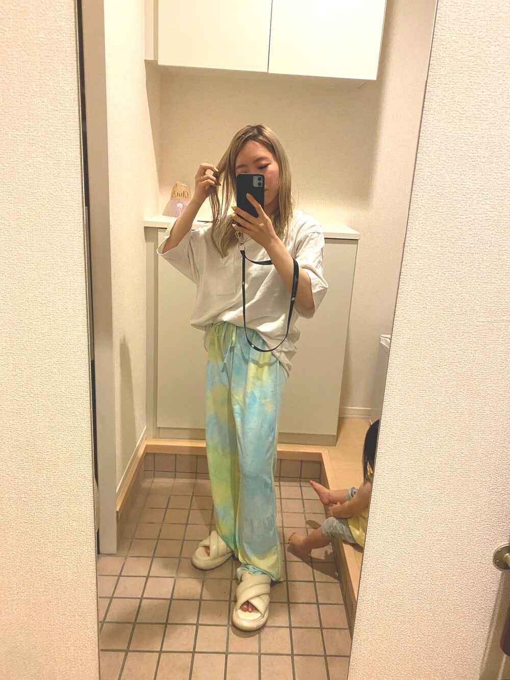 イエロー系のその他パンツ、ホワイト系のTシャツ/カットソー、ホワイト系のサンダルを着用したレディースの夏コーディネートの2枚目の写真