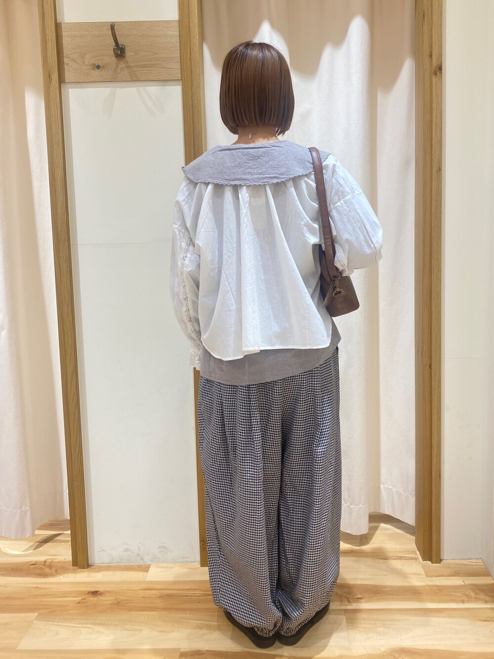 ホワイト系のシャツ/ブラウス、グレー系のその他パンツ、ブラウン系のハンドバッグを着用したレディースの春コーディネートの3枚目の写真