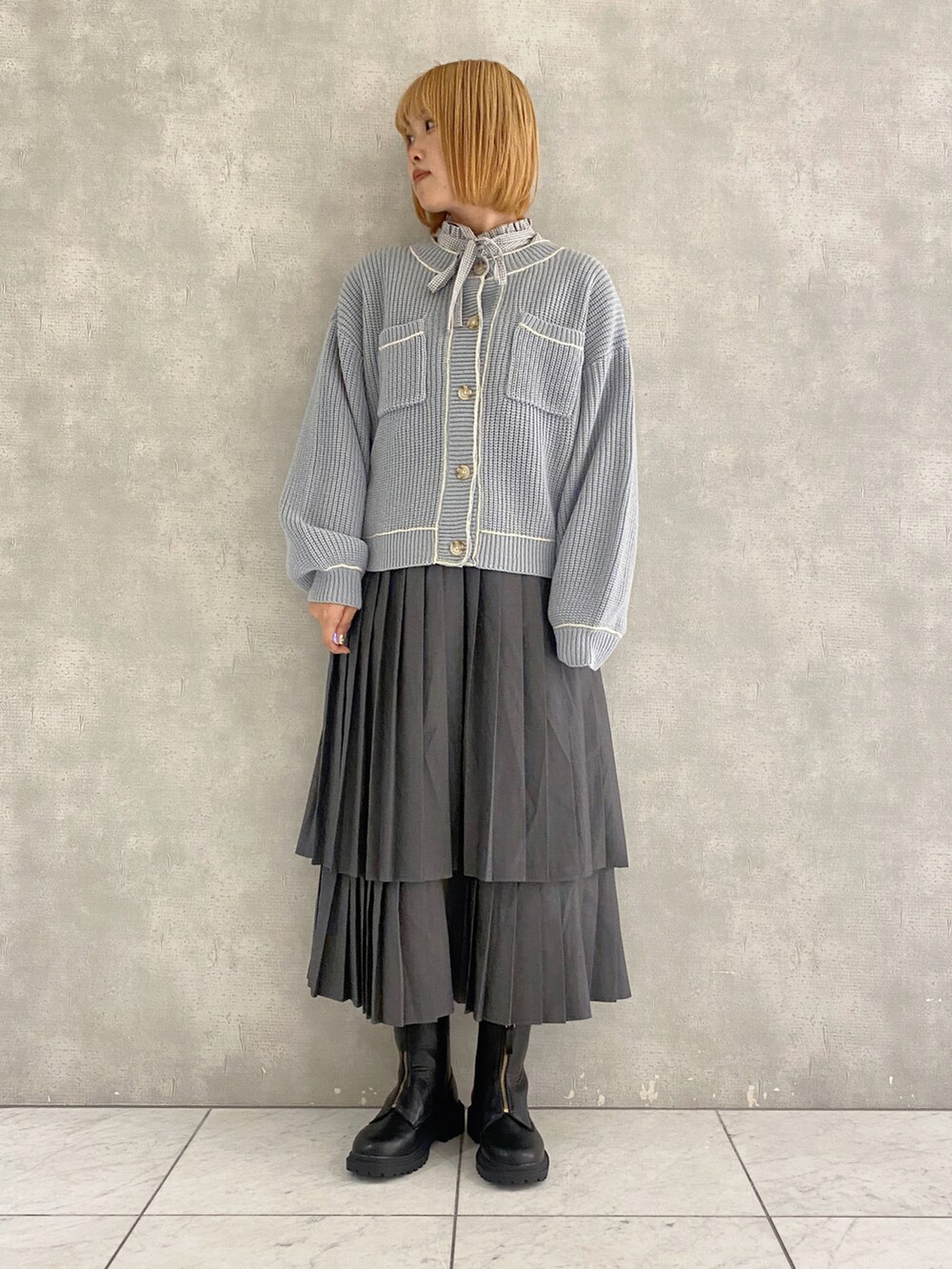 グレー系のスカート、ブルー系のカーディガン/ボレロ、グレー系のシャツ/ブラウスを着用したレディースの秋コーディネートの3枚目の写真
