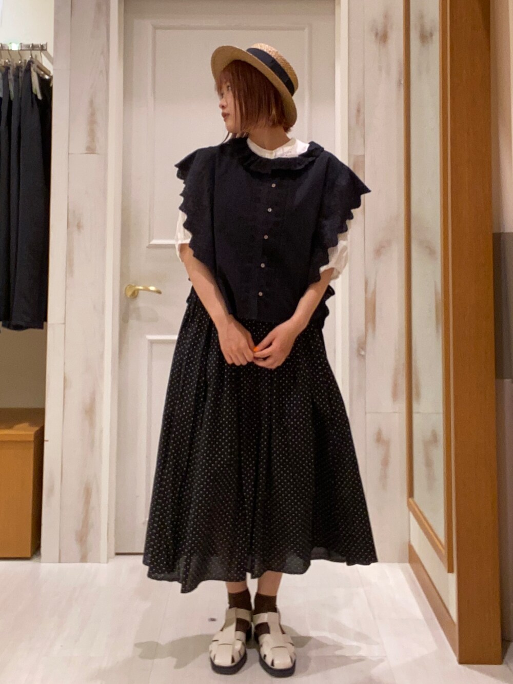 ブラック系のベスト、ブラック系のスカート、ホワイト系のシャツ/ブラウスを着用したレディースの春コーディネートの2枚目の写真